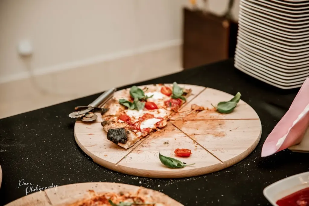 Pokrojona pizza z bazylią na desce
